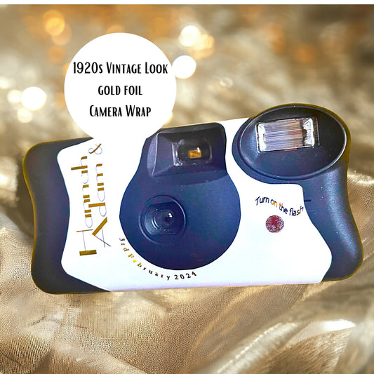 1920s Great Gatsby theme gold foil Kodak FunSaver disposable wedding camera stickers.  Personalised on the front and the reverse with your names and the date of your wedding. Pictured on a background of straw.